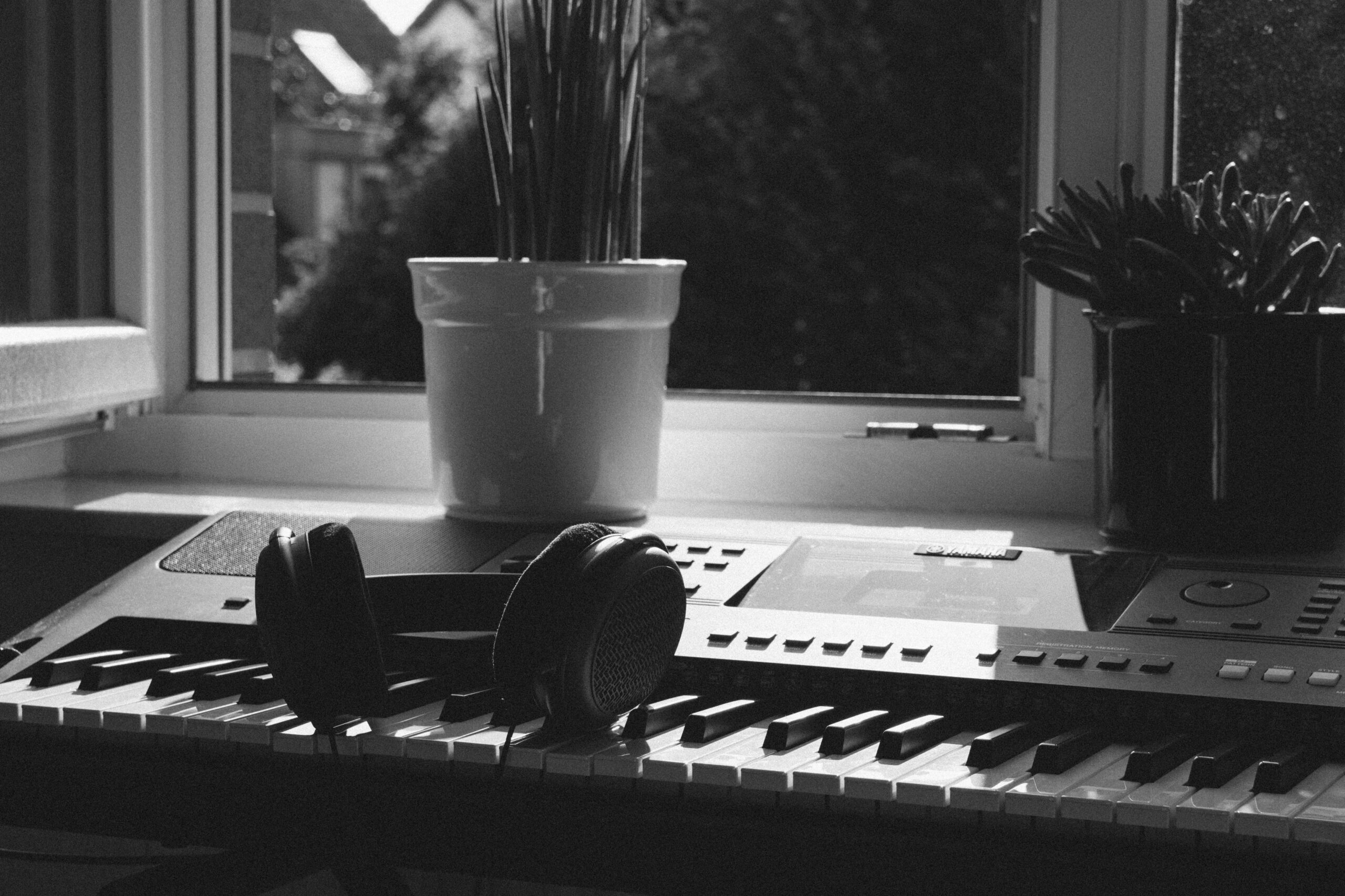 ヘッドホンと鍵盤が置かれた作曲の机